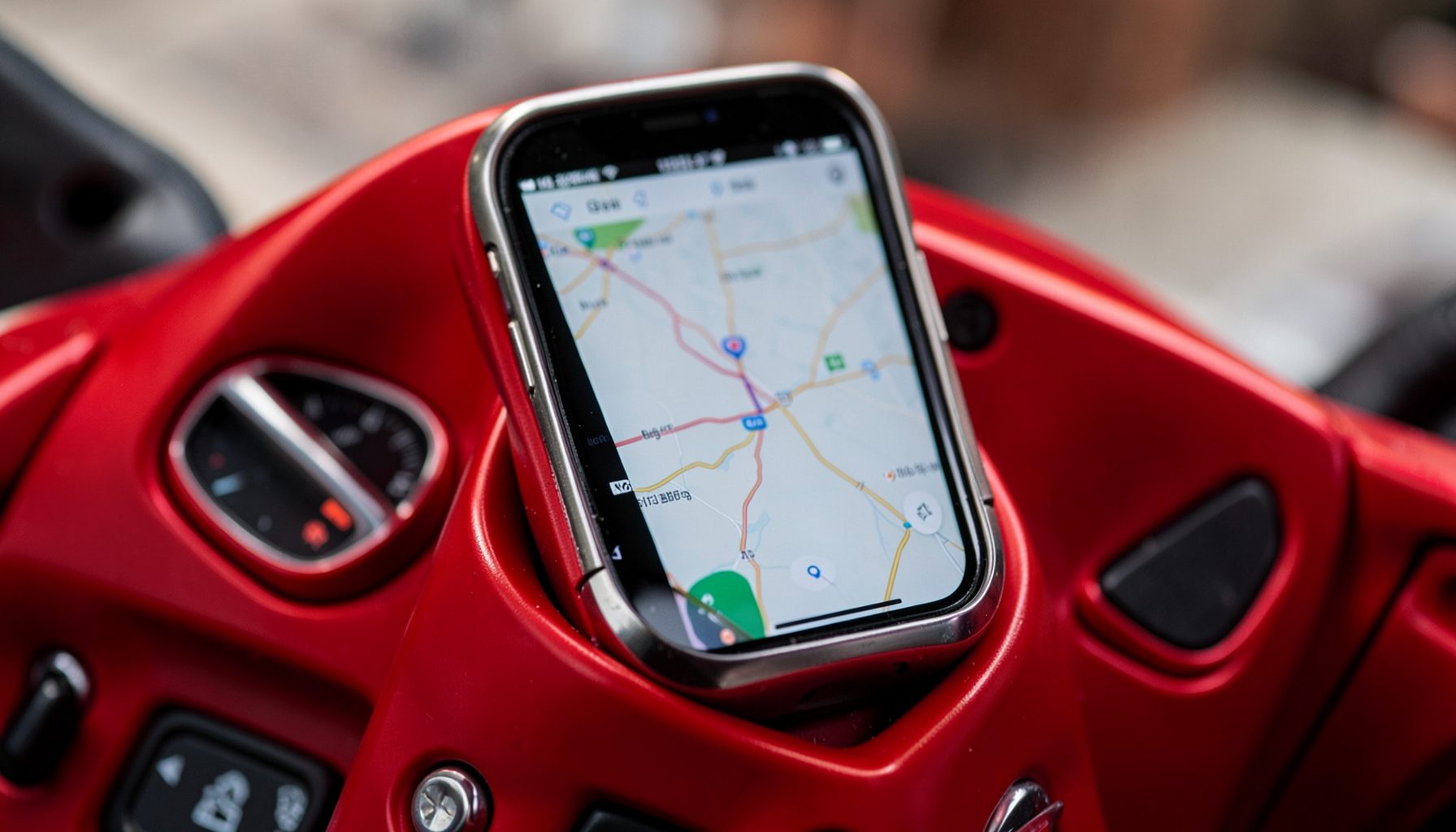 Dasbor motor dengan dudukan smartphone yang terpasang kokoh, menampilkan rute navigasi di layar